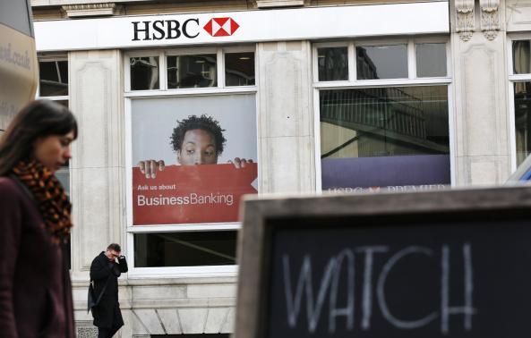 Pedestrians walk past a branch of HSBC bank in London