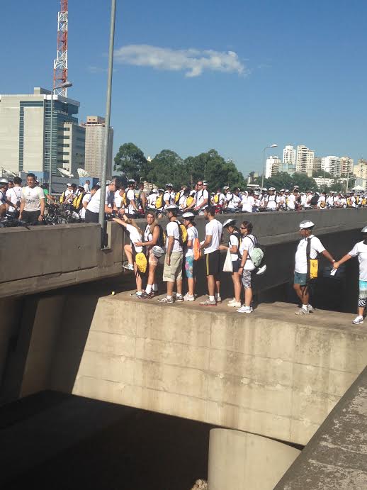 Os participantes tentam buscar suas bicicletas atravessando uma das alças da ponte