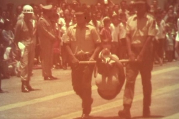 No desfile dos índios para as autoridades, um homem é carregado no pau de arara em público
