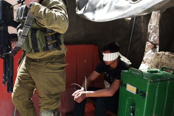 Palestino é preso e vendado por soldado israelense