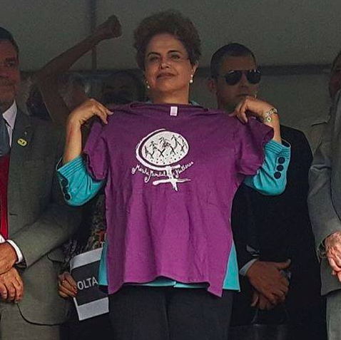 Dilma mostrando a camisa da Marcha Mundial das Mulheres, que ganhou de presente das feministas baianas