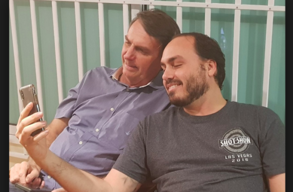 Carlos Bolsonaro com o pai mexendo no celular