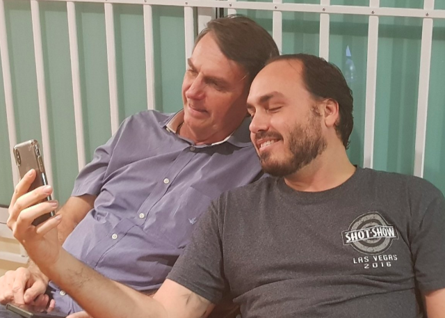 Carlos Bolsonaro com o pai mexendo no celular