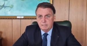 Bolsonaro de terno e gravata trabalhando no Planalto