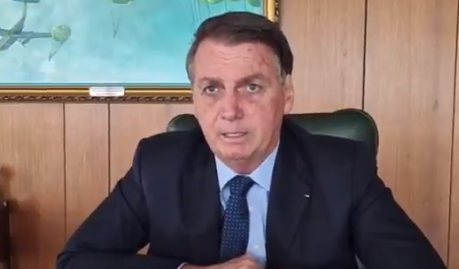 Bolsonaro de terno e gravata trabalhando no Planalto