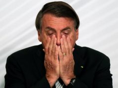 Jair Bolsonaro com as mãos no rosto