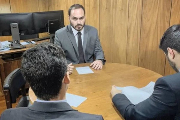 Carlos Bolsonaro faz pose de que está trabalhando.