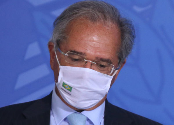 Paulo Guedes de máscara com a cabeça baixa