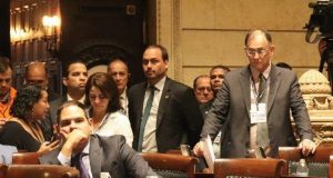 Carlos Bolsonaro cercado de dois guarda-costas no plenário da Câmara de Vereadores do Rio de Janeiro