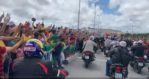 O público que acompanha o presidente está com camisa da seleção e bandeira do Brasil