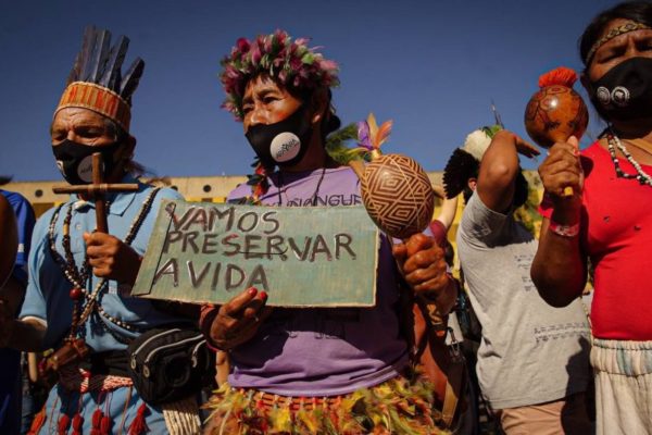Mulheres indígenas usam máscara em manifestação contra o PL 490