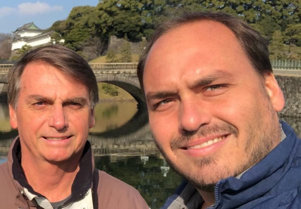 Jair Bolsonaro e Carlos Bolsonaro tirando foto juntos