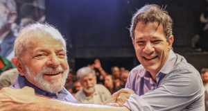 Lula e Haddad se cumprimentam sorrindo e posam para foto