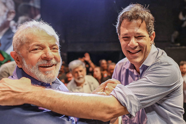 Lula e Haddad se cumprimentam sorrindo e posam para foto