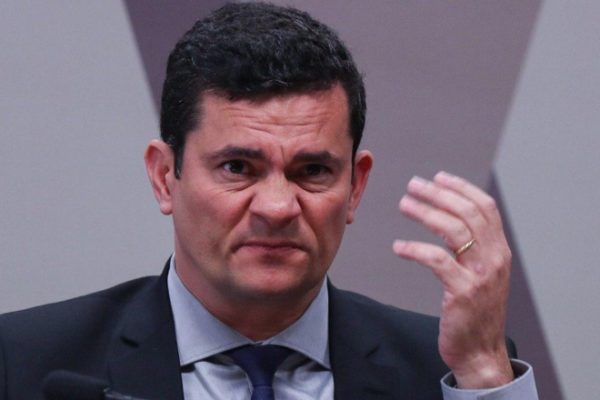 Sérgio Moro fazendo careta com a mão erguida