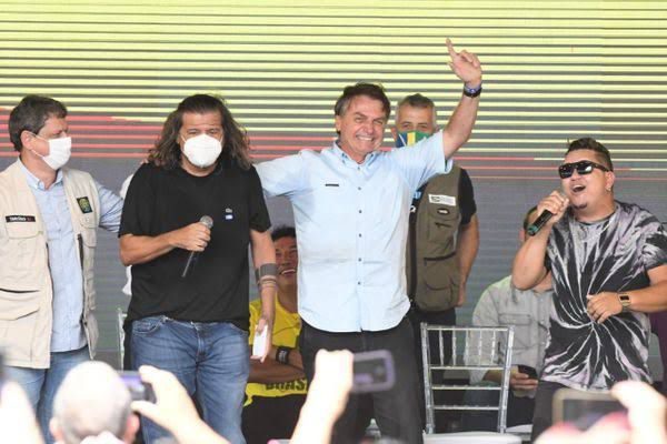 Daniel da Açaí, de máscara, abraçado com Jair Bolsonaro durante evento em São Mateus
