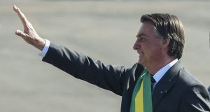 Bolsonaro acena com faixa presidencial