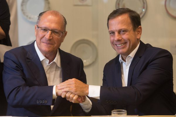 Geraldo Alckmin e João Dória de mãos dadas em cumprimento