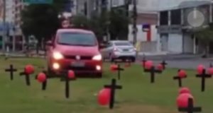 Carro passa por cima de cruzes