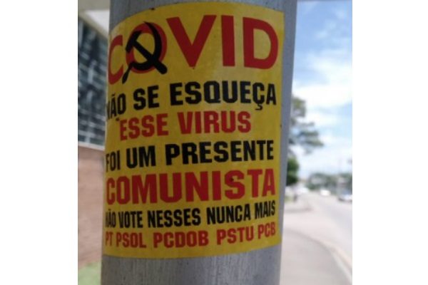 Cartaz sobre Covid-19 em poste