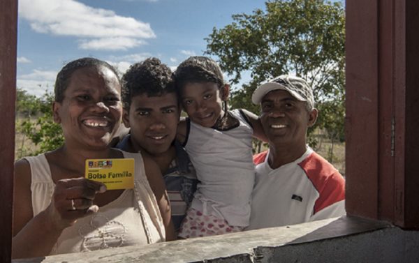 Família exibe cartão do Bolsa Família