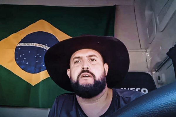 Zé Trovão num caminhão e a bandeira do Brasil atrás