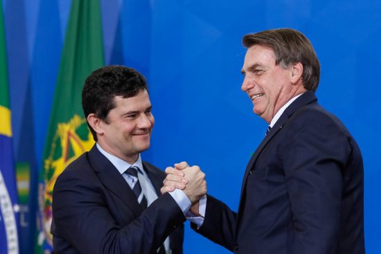 Moro e Bolsonaro se cumprimentando com as mãos