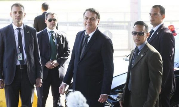 Jair Bolsonaro cercado por segurança