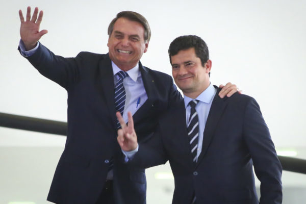 Moro e Bolsonaro abraçados e cumprimentando pessoas, que não aparecem na imagem