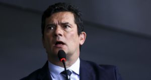 Moro em pé, com um microfone na frente dele