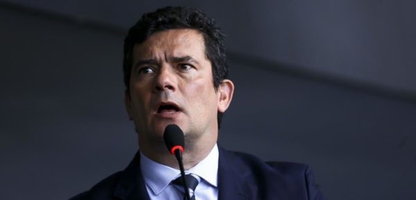 Moro em pé, com um microfone na frente dele