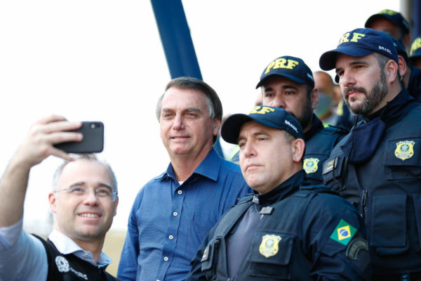 Bolsonaro e o ex-ministro da Justiça ao lado de agentes da PRF