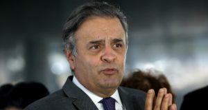 Aécio Neves falando e com as mãos unidas