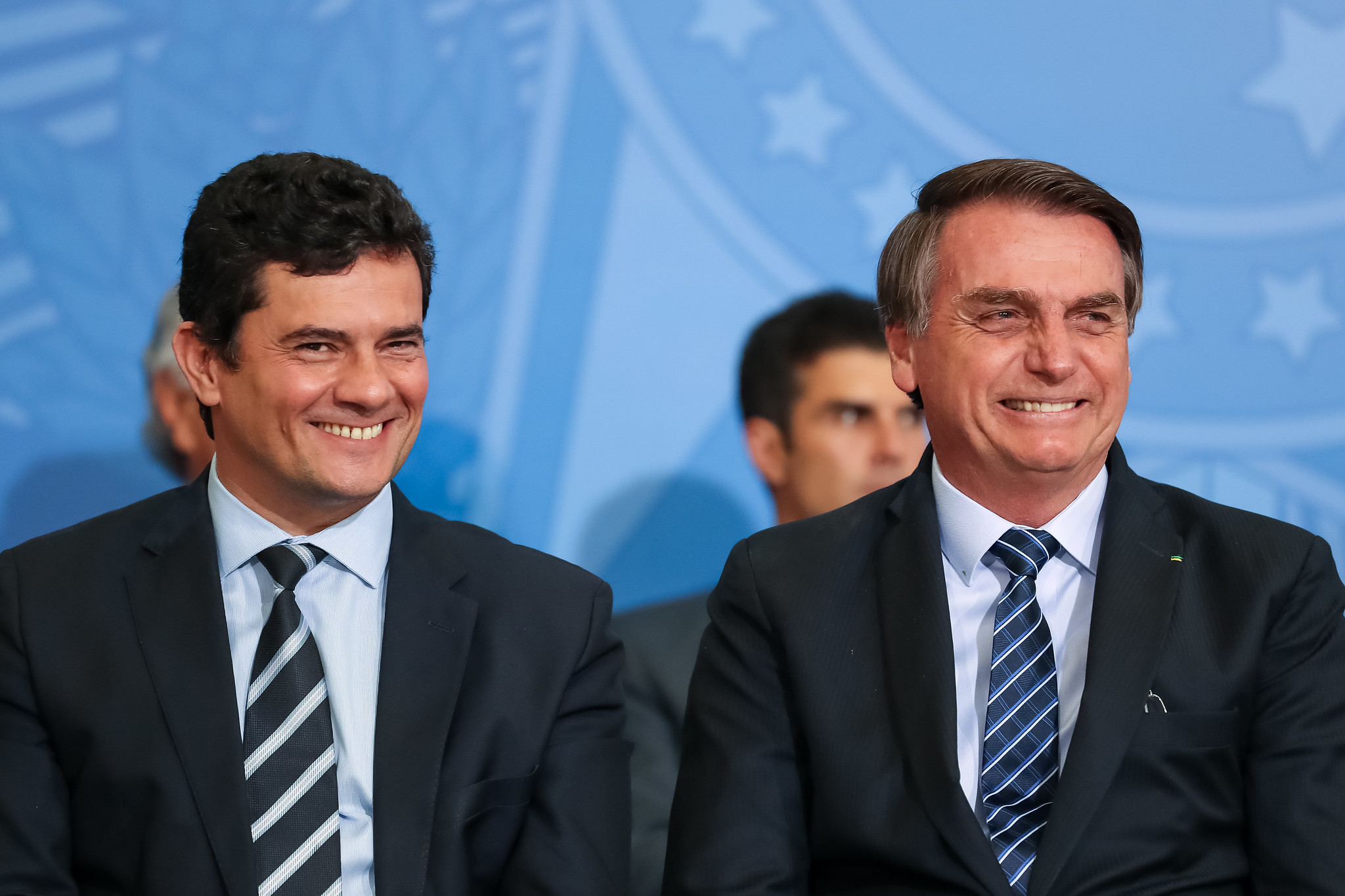 Sergio Moro e Jair Bolsonaro lado a lado, sorrindo.