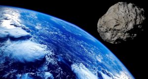 A Terra, vista do universo, com um asteroide perto