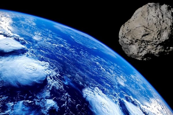 A Terra, vista do universo, com um asteroide perto