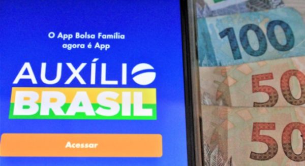 Celular com Auxílio Brasil e notas de dinheiro