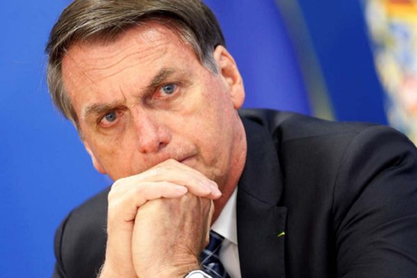 Bolsonaro sentado com as mãos no queixo