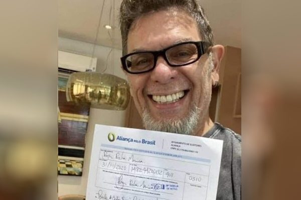 Roger sorrindo com papel