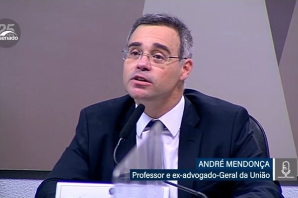 André Mendonça sentado, no Senado, com um microfone à sua frente