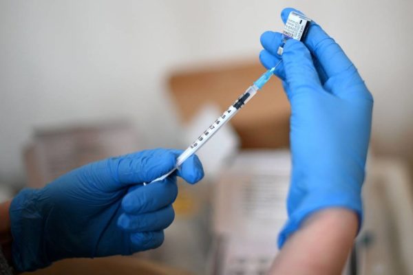 Dose de vacina em mãos