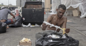 Reginaldo Gonçalves da Silva, de 41 anos, separa comida que iria para o lixo, em São Paulo. Danilo Verpa/Folhapress