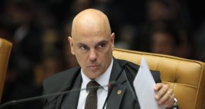 Foto de Alexandre de Moraes com olhar sério. Ele é calvo e está em uma cadeira no plenário do STF