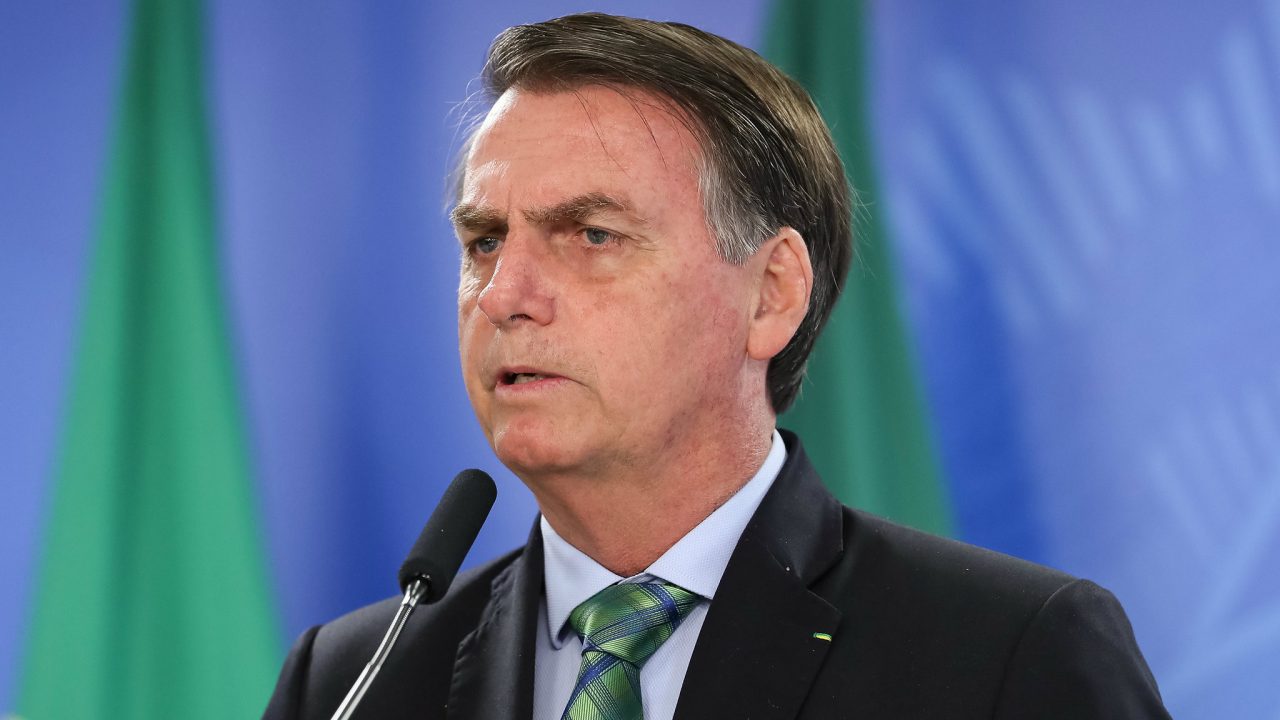 Bolsonaro discursando com terno e gravata