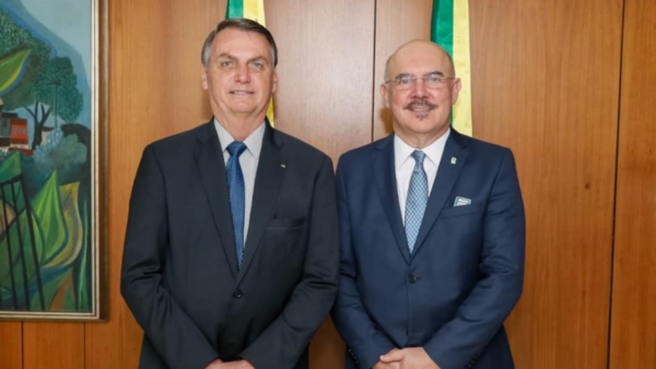 Foto de Bolsonaro e o ministro da educação Milton Ribeiro, ambos sorrindo e posando para a foto.