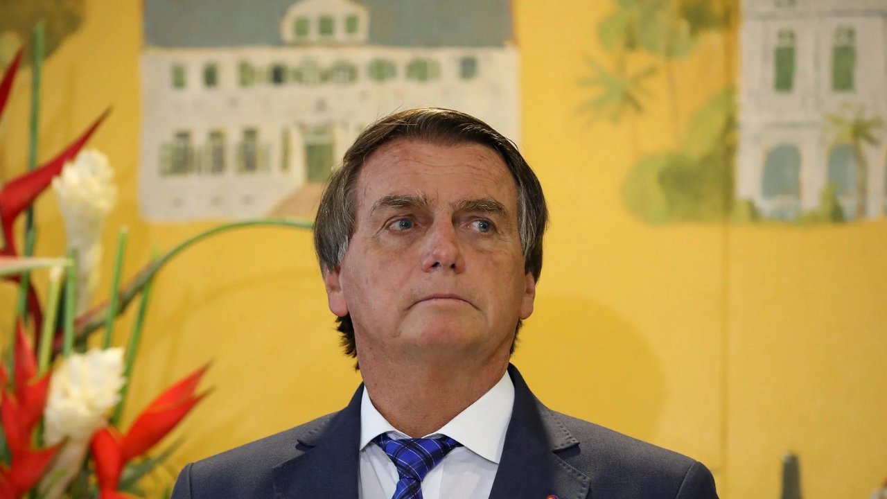 Foto de Bolsonaro com olhar pensativo, a cabeça está levemente inclinada para o lado direito da foto. Ele usa terno.