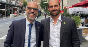 Foto de Allan dos Santos e Eduardo Bolsonaro juntos. Eles usam terno.