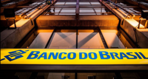 Foto de fachada do Banco do Brasil com letreiro em azul com fundo amarelo.