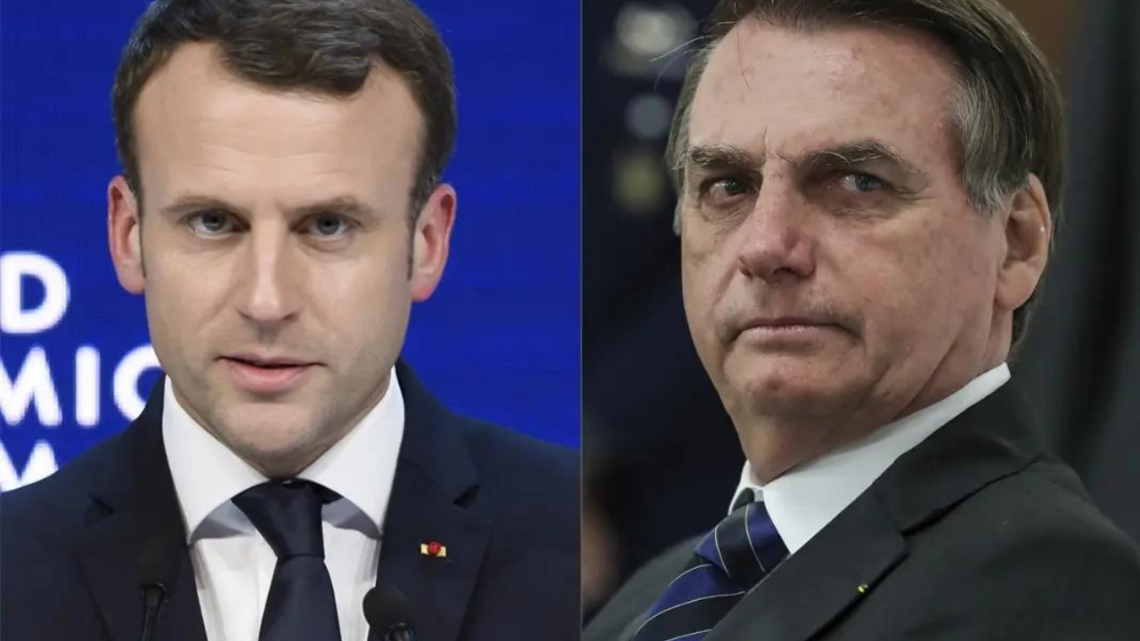 Foto de Macron (à esquerda) e Bolsonaro (à direita). Macron está sem barba, pele branca e cabelos castanhos. Bolsonaro também não usa barba, tem cabelo grisalho e olhar sério.