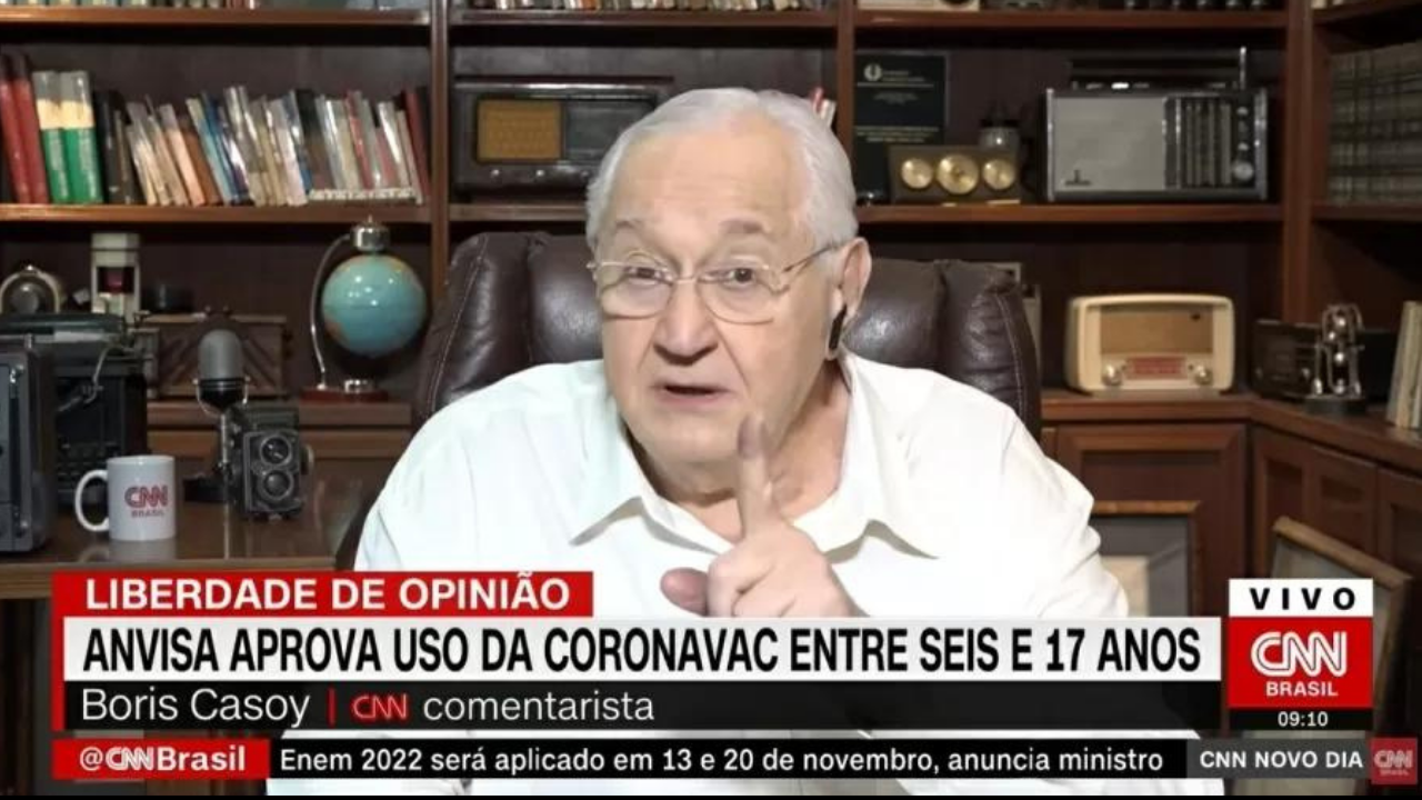 Foto de Casoy durante comentário na CNN. Ele usa camisa branca e usa óculos. Ele também tem cabelo branco.